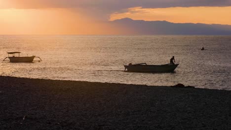 Lokaler-Fischer-Auf-Einem-Fischerboot,-Das-Während-Eines-Wunderschönen-Sonnenuntergangs-Auf-Der-Tropischen-Insel-Timor-Leste-Den-Ankerplatz-Entfernt