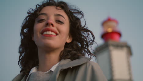 closeup travel girl looking camera at evening lighthouse view. happy woman dream