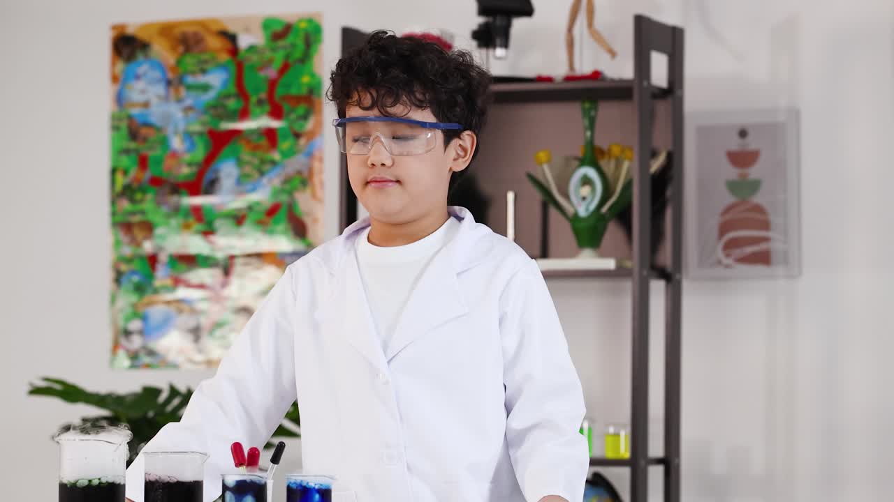 安全ゴーグルと白衣を着た少年が教室で実験をしている様子
