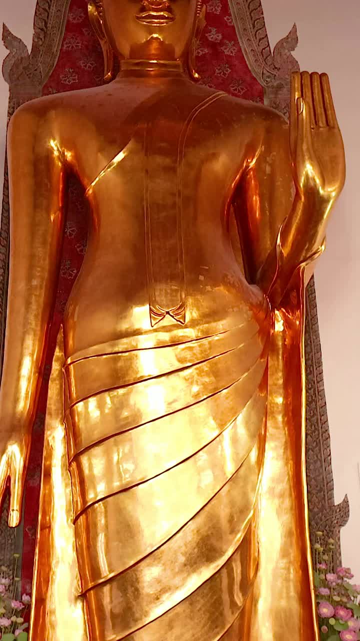 un video sereno que muestra la majestuosa estatua dorada de buda en wat pho, bangkok, con detalles intrincados del templo y iluminación suave