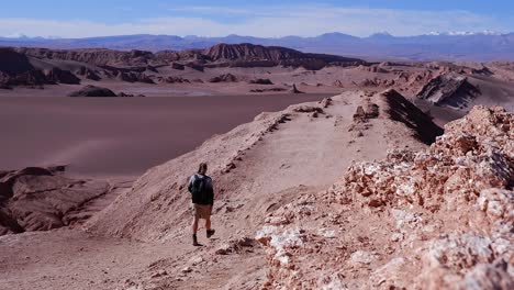 stunning natural desert viewpoint, male hiker walks on gravel ridge