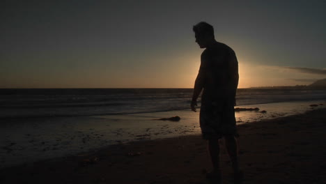 a man stands alone on a windy beach