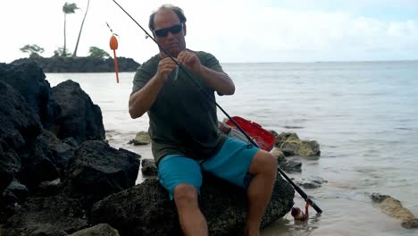pescador con aparejos de pesca en la playa 4k