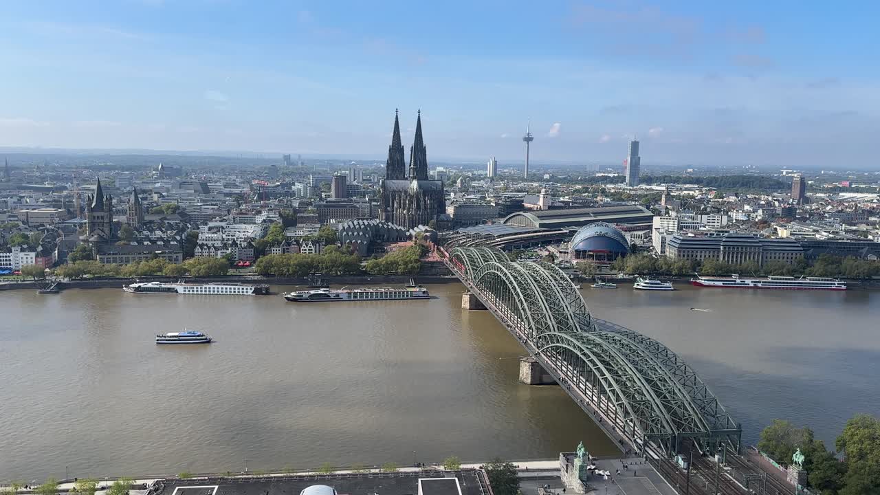 Drone aerial of Cologne skyline featuring famous cathedral and railway bridge crossing the Rhine river in western Germany