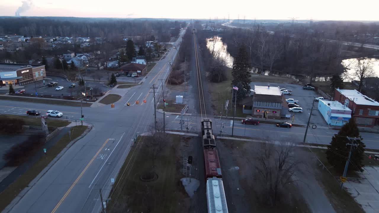 el tren de carga pasa por la pequeña ciudad de south rockwood en michigan, el dron aéreo sigue la vista