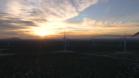 wind farm at sunset with wind turbines in a desert landscape