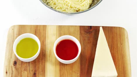 cheese slice and sauce on cutting board with boiled pasta