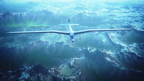 An-aerial-view-of-the-white-sailplane-with-no-propeller-calmly-gliding-in-the-sky,-over-snow-covered-mountains.-Flying-aerodynamic-aircraft-is-a-great-way-of-spend-leisure-time.