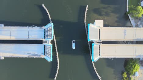 aerial video of a small drawbridge closing after boats have passed through the channel