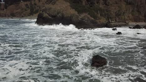 aerial waves crashing against beach in oregon