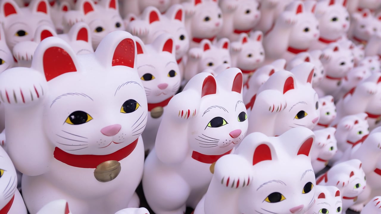 Tiheä kokoelma Maneki-neko-patsaita Tokion onnenkissatemppelissä.