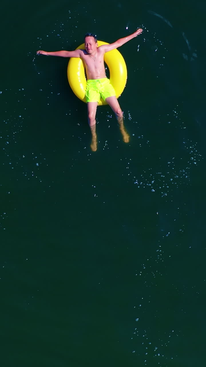 Boy swimming with swim ring. Happy little boy swimming with colorful ring