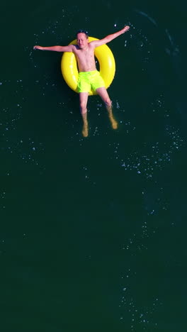 boy swimming with swim ring. happy little boy swimming with colorful ring