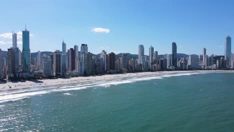 Toma-De-Drone-De-Balneario-Camboriu-Brasil,-Desde-El-Mar,-De-La-Playa-Y-Edificios-En-El-Fondo