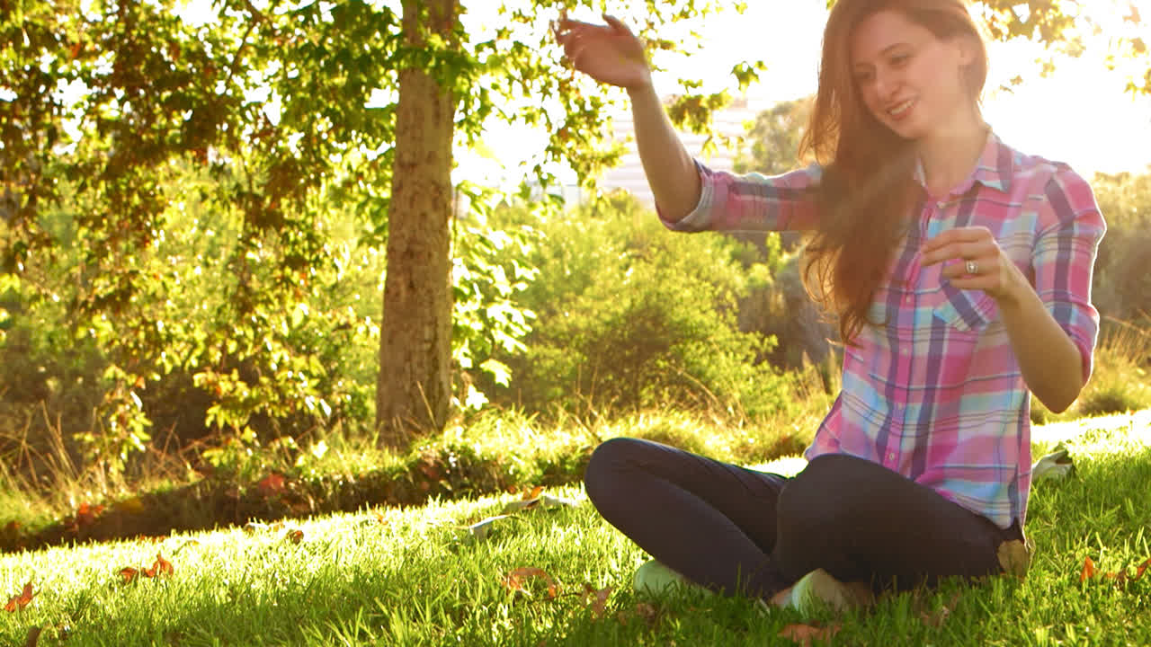 una mujer joven lanza un juguete para que lo recoja un perro peludo blanco