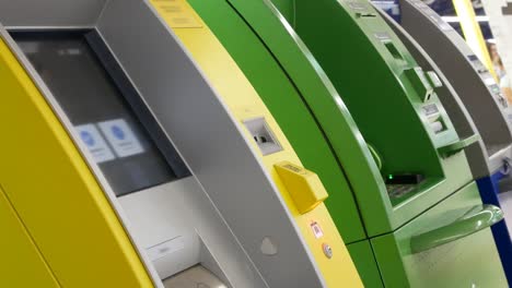 close-up of the hands of a man inserting a card into the atm reader to start a payment session