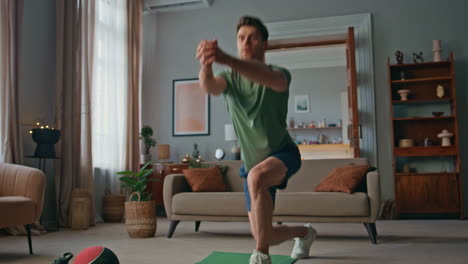 active sportsman making squats in living room. focused young man training body