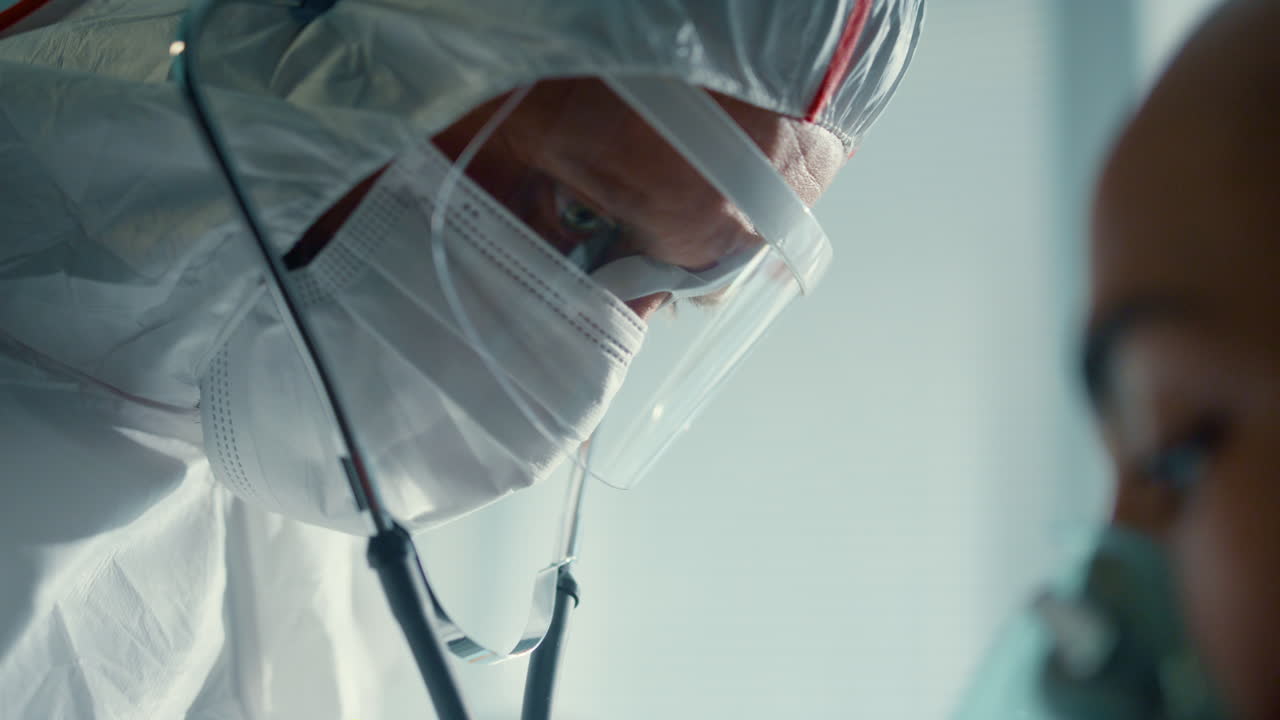 Medico che ascolta il battito cardiaco del paziente con lo stetoscopio in reparto clinico, primo piano.