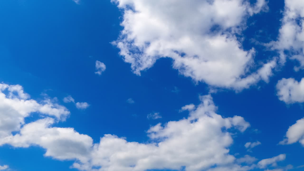 Clouds moving timelapse. Clouds drift dynamically across a clear blue sky, showcasing a beautiful natural timelapse effect over time