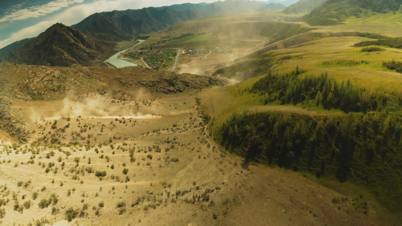 el terreno de las tierras altas se convierte en terreno para el motocross. las motocicletas patean nubes de polvo acelerando a lo largo del curso montañoso. batalla dinámica contra el paisaje