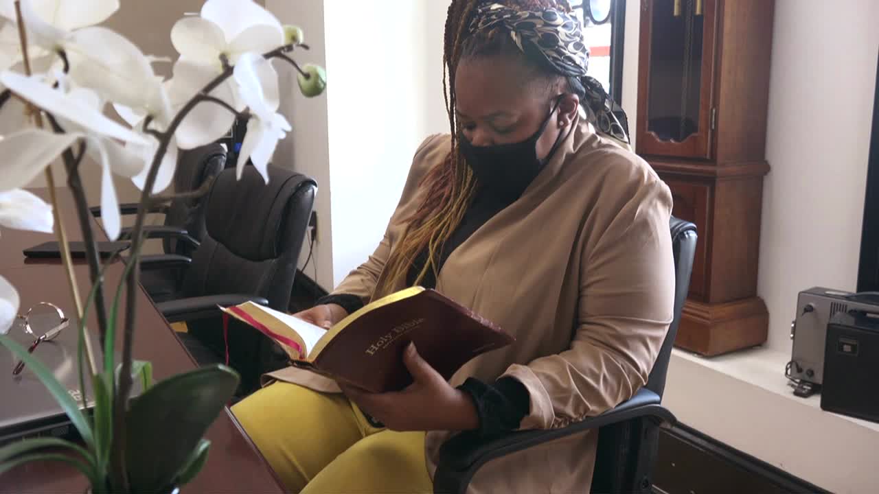 mujer leyendo la biblia mientras usa máscara