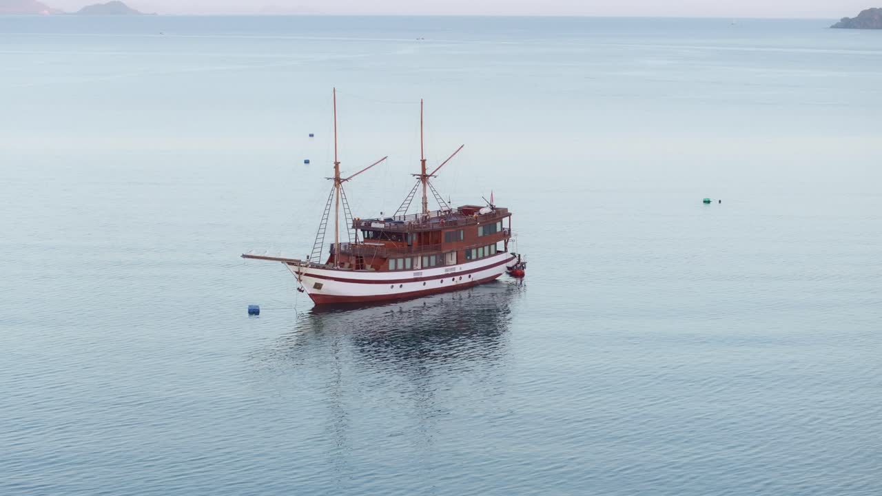 Cahaya pagi pada perahu yang tertambat di teluk kecil, Labuan Bajo, Flores, Indonesia