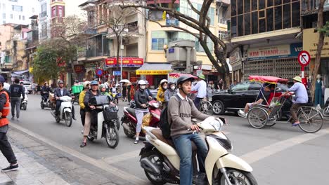 pedestrians and vehicles navigating a busy city crossroad.