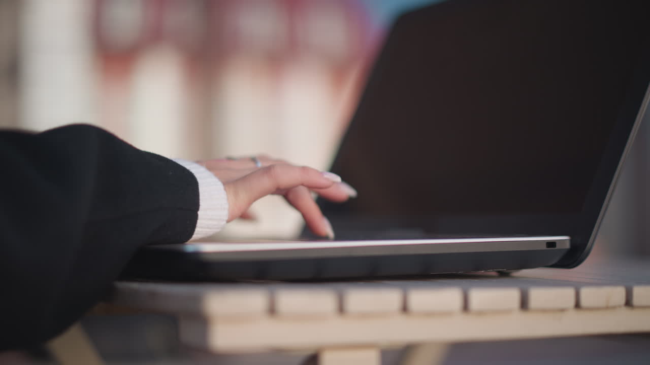 은 손과 섬세한 반지로 장식 된 손의 측면 뷰 노트북 키보드에서 타이핑, 약간 흐릿한 효과는 노트북 화면에서 보이는 미묘한 반사와 함께 부드러움을 추가합니다.