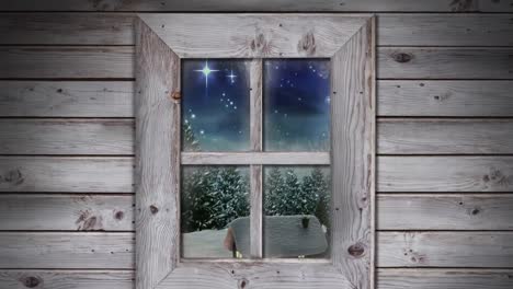 wooden window frame against snowflakes falling over multiple houses and trees on winter landscape