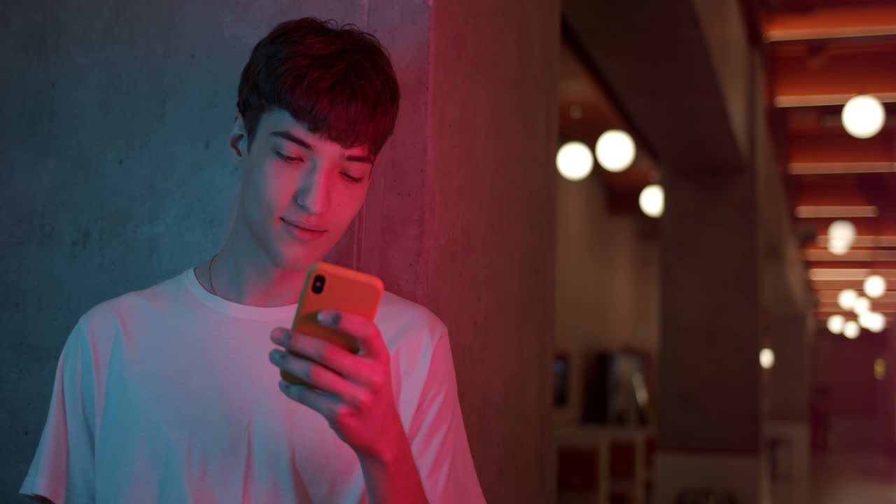 Man using smartphone in neon light