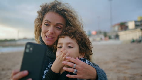 Madre-E-Hijo-Tomando-Selfie-En-El-Primer-Plano-De-La-Playa-Del-Océano.-Sonriente-Hermosa-Madre-Descanso