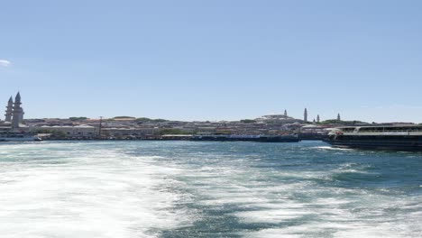 a view of istanbul from the water with a mosque in the background.