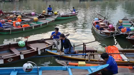 boatmen on rowboats take a break and prepare for a busy night taking tourist on a ride along thu bon river at a section of the old quarter in the city of hoi an, vietnam.
