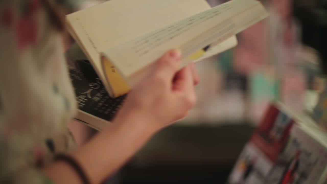 Close-up of hands turning pages of a book