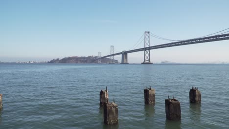 Toma-Fija-De-Autos-Que-Cruzan-El-Puente-De-La-Bahía-En-Un-Día-Tranquilo-Y-Soleado-En-San-Francisco