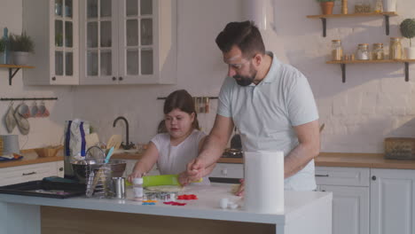 father and daughter baking cookies together