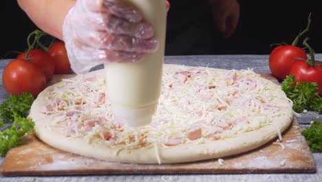 preparing a pizza with sauce