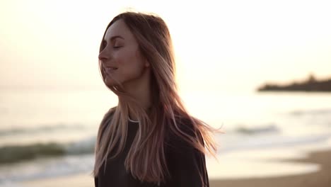 retrato de una mujer caminando a lo largo de la playa y sonriendo, noche de la orilla del mar de otoño