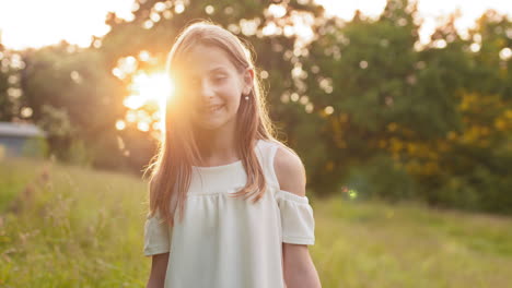 girl smiling in a field at sunset
