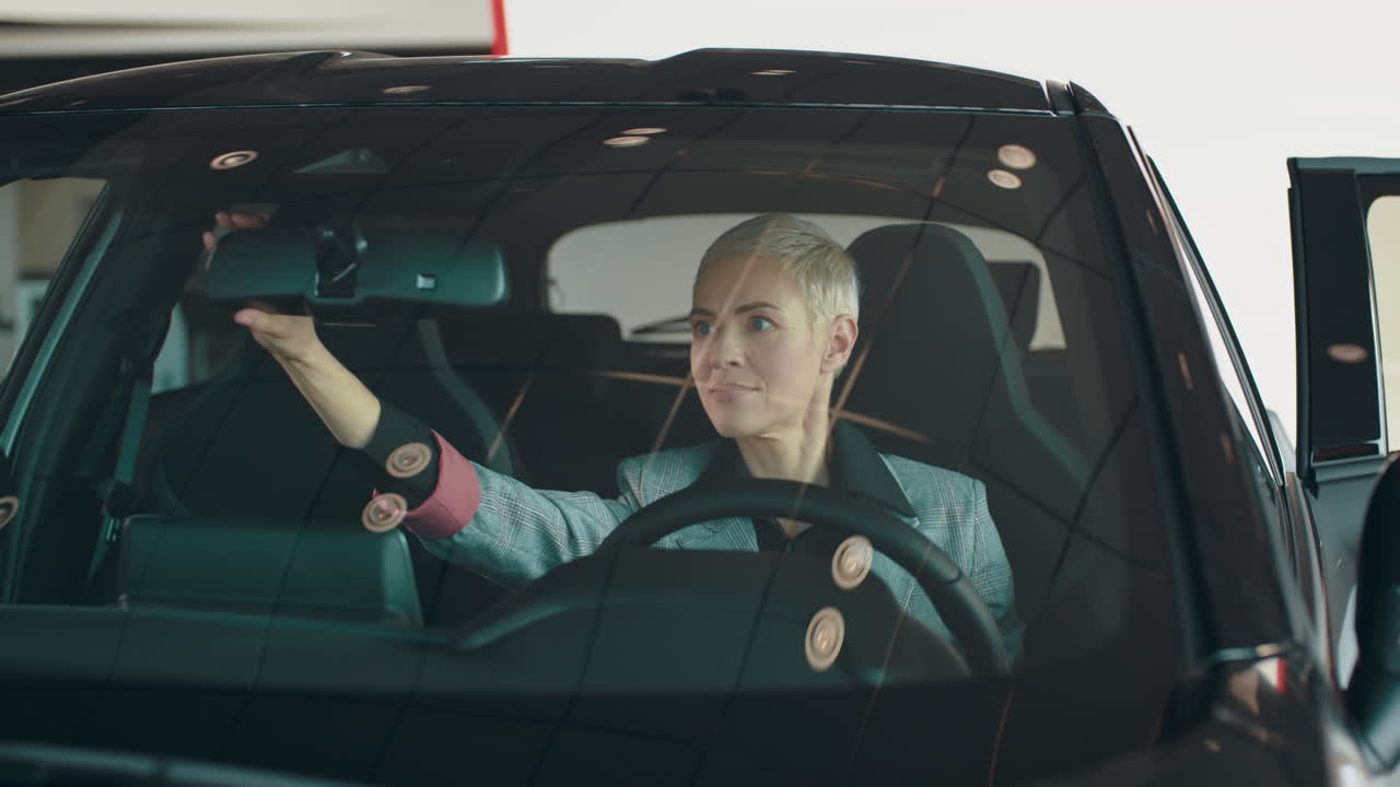 mujer ajustando el espejo del coche