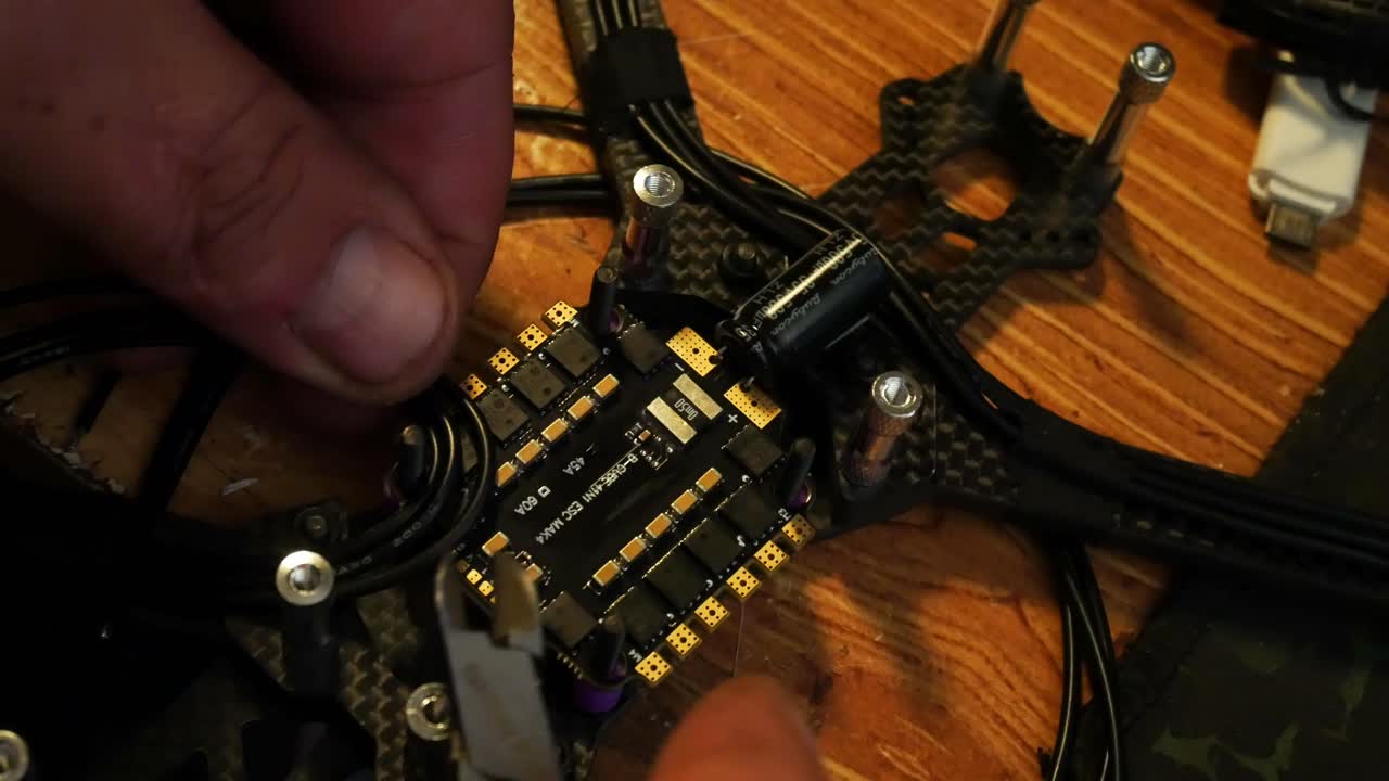 Close up preparing wiring arrangement for FPV drone hobby build on the controller circuit board