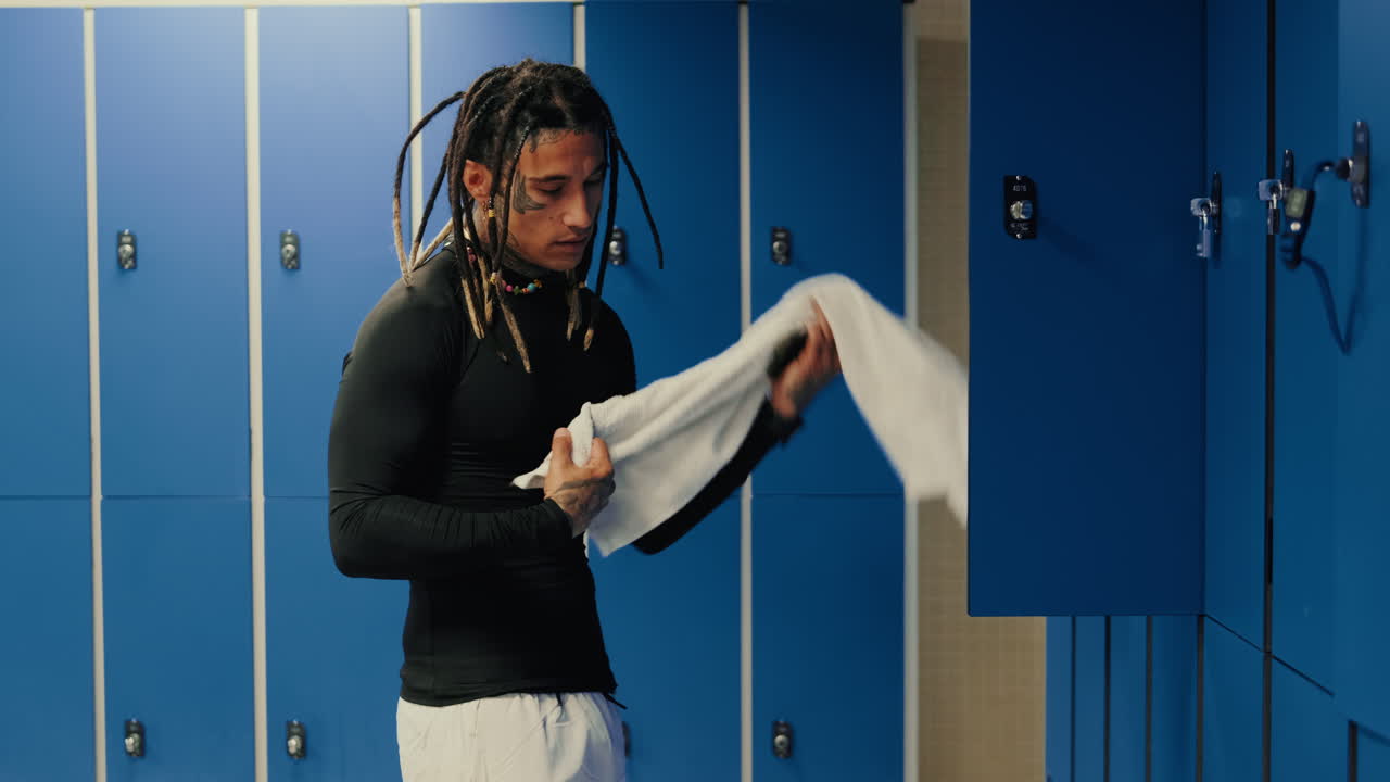 Athlete with Dreadlocks Getting Ready in Locker Room