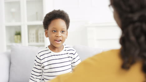 Linda-Niña-Pequeña-Corriendo-Hacia-La-Madre-Y-Abrazándose-Fuerte-En-El-Sofá-En-La-Sala-De-Estar