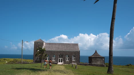 Two-young-girls-walking-towards-a-stone-church-on-St