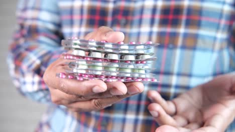 person holding a stack of medication blisters