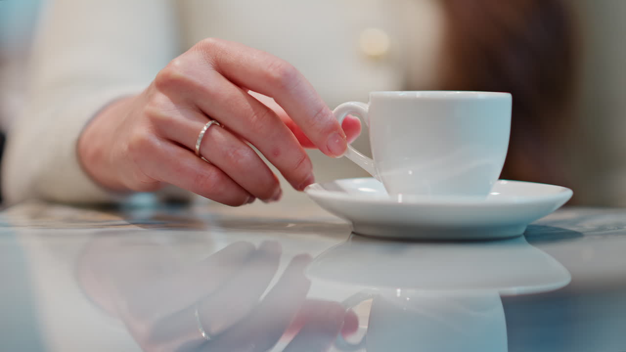 Woman holding a cup of coffee on a table