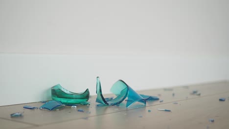 broken teal glass on wooden floor