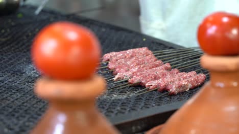 Cooking-skewers-on-the-grill-in-the-street-food-market-in-Marrakech,-Morocco