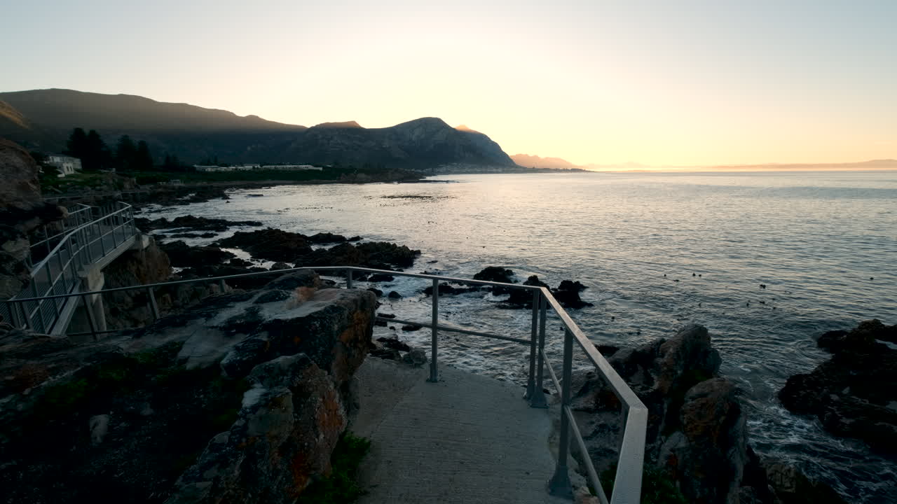 Yellow and orange sky at sunrise over ocean viewed from Poole's Bay coastal path