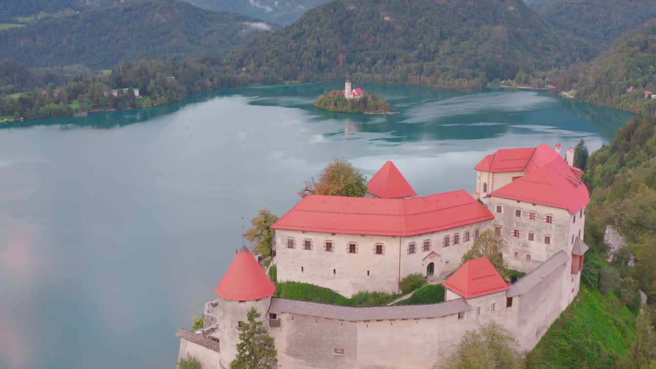Vista vivace del Castello di Bled sulla riva del lago e dell'isola di Bled in lontananza, in Slovenia.